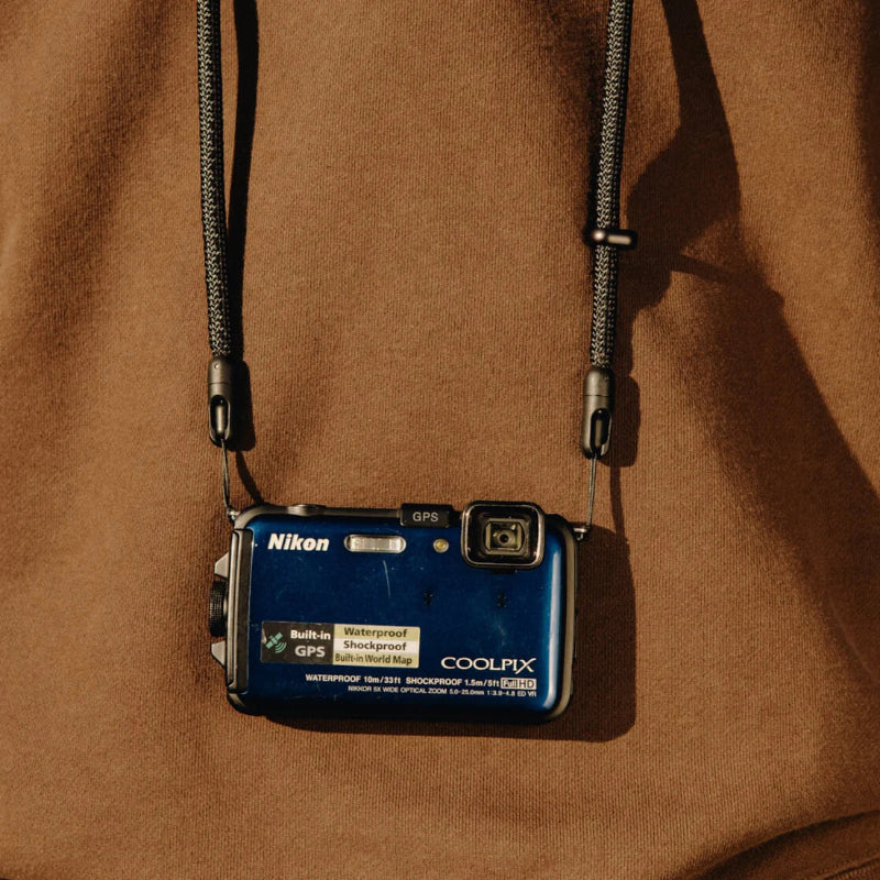 Nikon digital camera with strap on a brown background