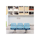 A row of three light blue plastic chairs sits in front of a white wall with Chinese characters and English text reading 'NO BALL GAMES', with a multi-story apartment building in the background.