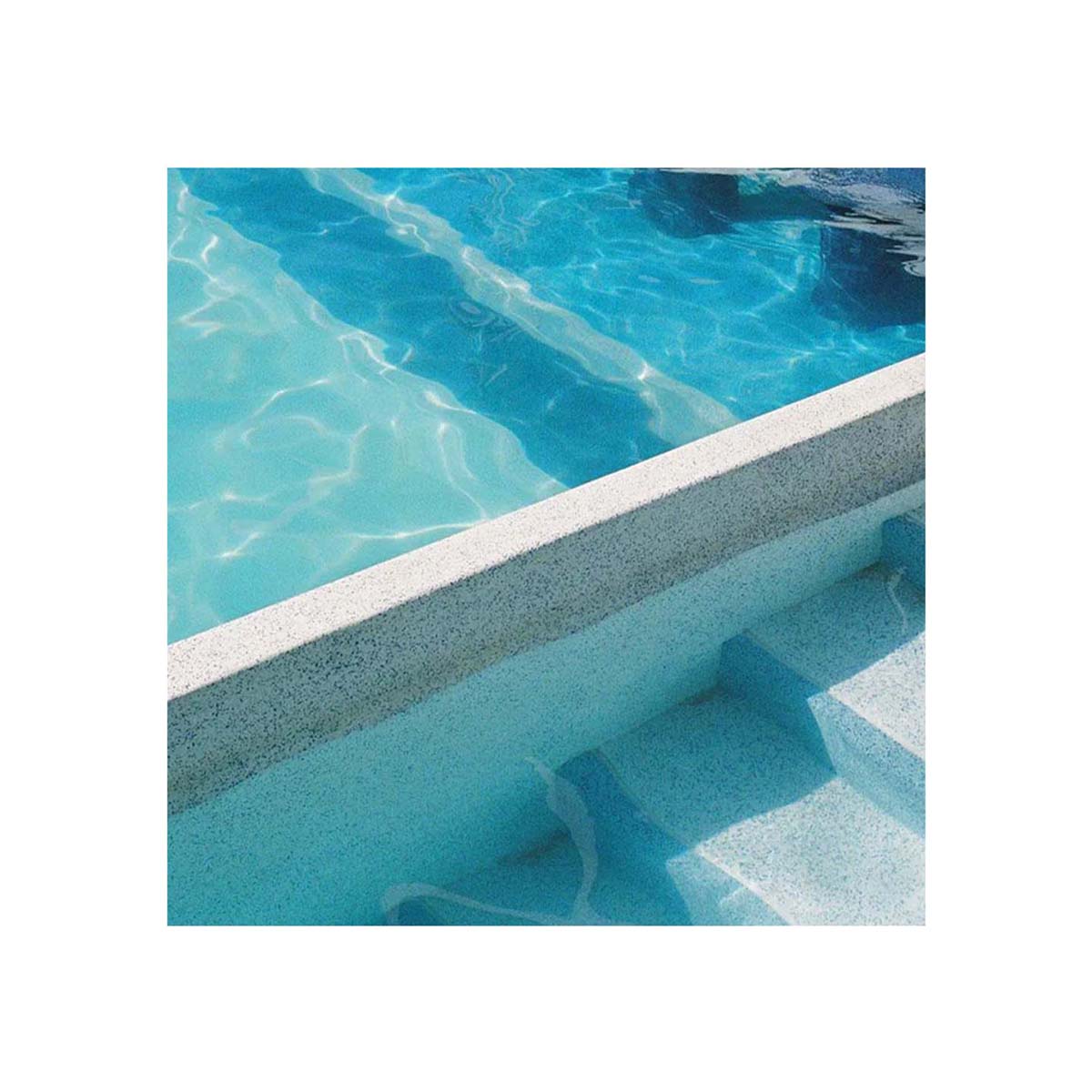 A close-up view of a swimming pool corner with bright blue water, a light gray concrete coping edge, and steps leading into the pool.