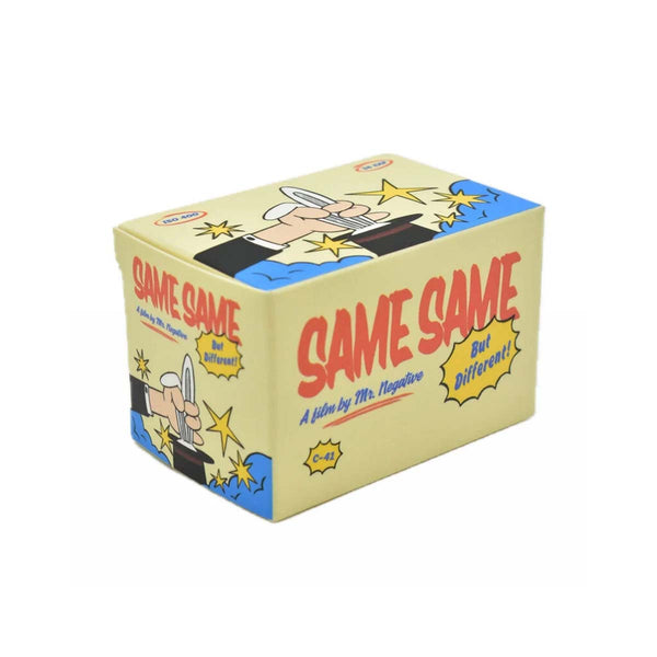 A novelty card deck box titled 'SAME SAME But Different!' featuring cartoon illustrations of a magician and stars on a light beige background with blue side panels.