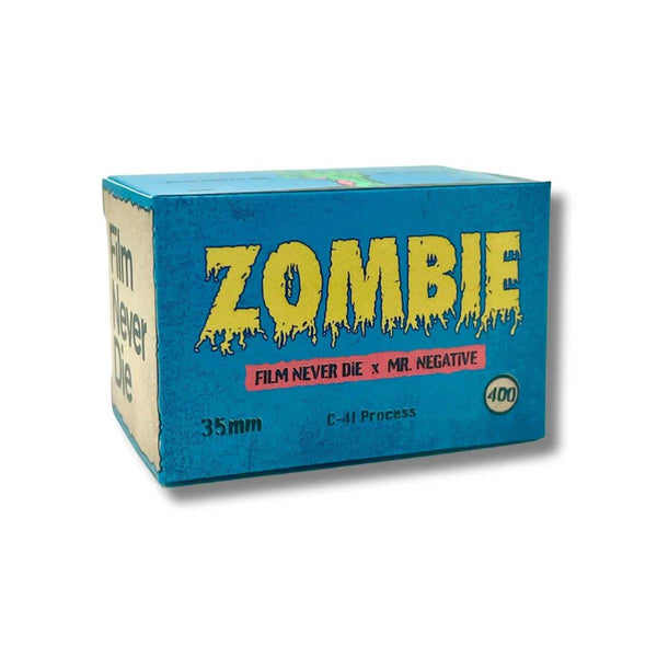 A blue cardboard box for 'Zombie Film Never Die' 35mm negative film, featuring a distressed yellow 'ZOMBIE' logo and a red banner with white text, shown on a white background.