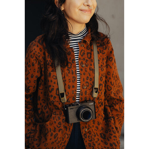 Person wearing a leopard print coat with a camera slung over their shoulder.