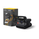 Black Polaroid Flip instant camera with a retractable lens cover and yellow wrist strap next to its product box.