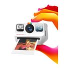 White Polaroid Go instant camera held by colorful hands, ejecting a small square color photo.
