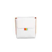 White polyester Polaroid camera bag with orange sides, a foldover flap, and a small rainbow brand tag.