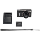 Canon camera with battery, charger, and strap on a white background