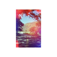 Winding road through a scenic landscape with trees and mountains.