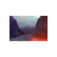 Winding mountain road with a car, featuring vibrant red and purple light-leak effects from Psychedelic Blues 35mm film.
