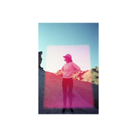 Person standing in a desert landscape with a vibrant pink rectangular light leak effect from Psychedelic Blues 35mm film.