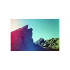 Rocky landscape captured on 35mm film with vibrant red light leaks and teal color shifts across the sky.