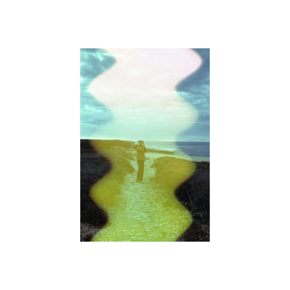 35mm film shot of a coastal path featuring a vertical, multi-colored wave effect with yellow and pink light leaks.