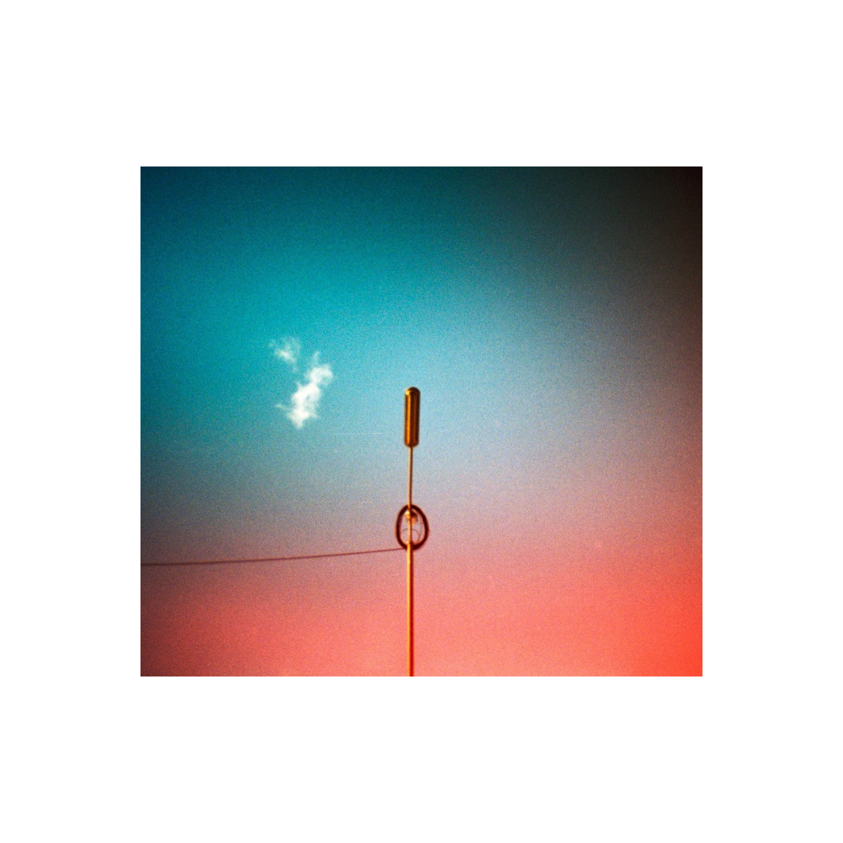 Revolog Kolor 200 film shot of a thin antenna against a sky with vibrant turquoise and orange color gradient washes.