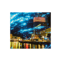 Night cityscape with REVOLOG Kosmos 35mm film featuring glowing blue stardust galaxy effects over a river and buildings.