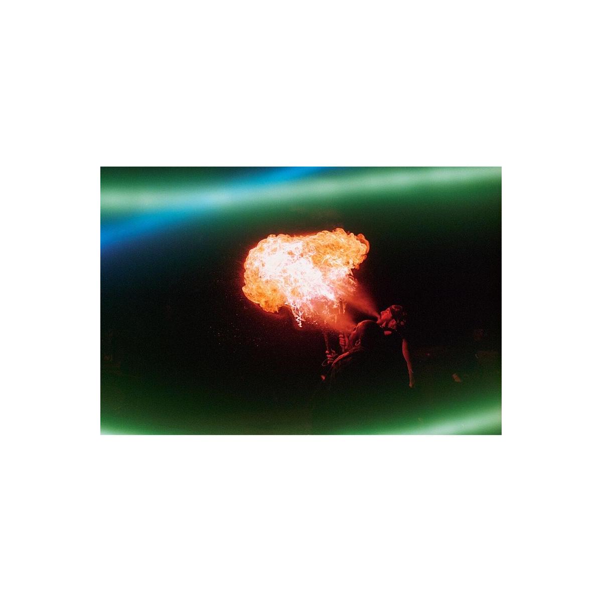 Fire breather at night captured on Revolog Lazer 35mm film with glowing blue and green electric light streaks.