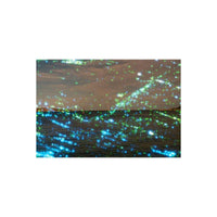 Seascape shot on Revolog Nebula 35mm film featuring blue and green stardust effects over a dark ocean and cloudy sky.