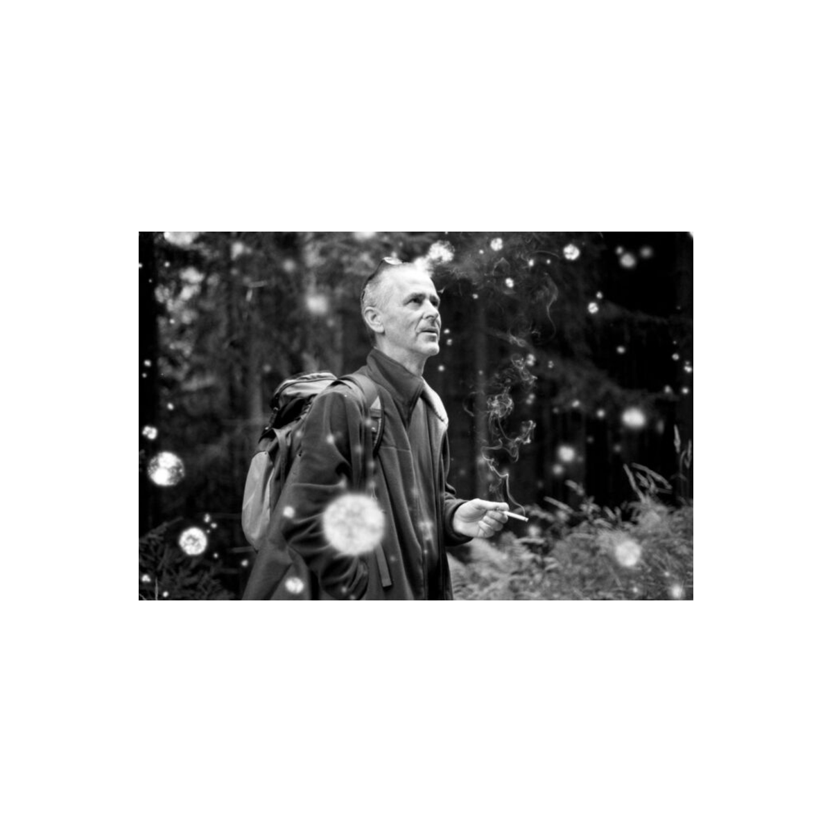 Black and white portrait of a man with a cigarette, featuring Revolog Snovlox film's signature white snow-like speckled effect.