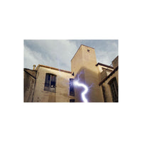 REVOLOG Tesla 1 35mm film shot of a building exterior featuring a prominent blue lightning bolt effect across the frame.