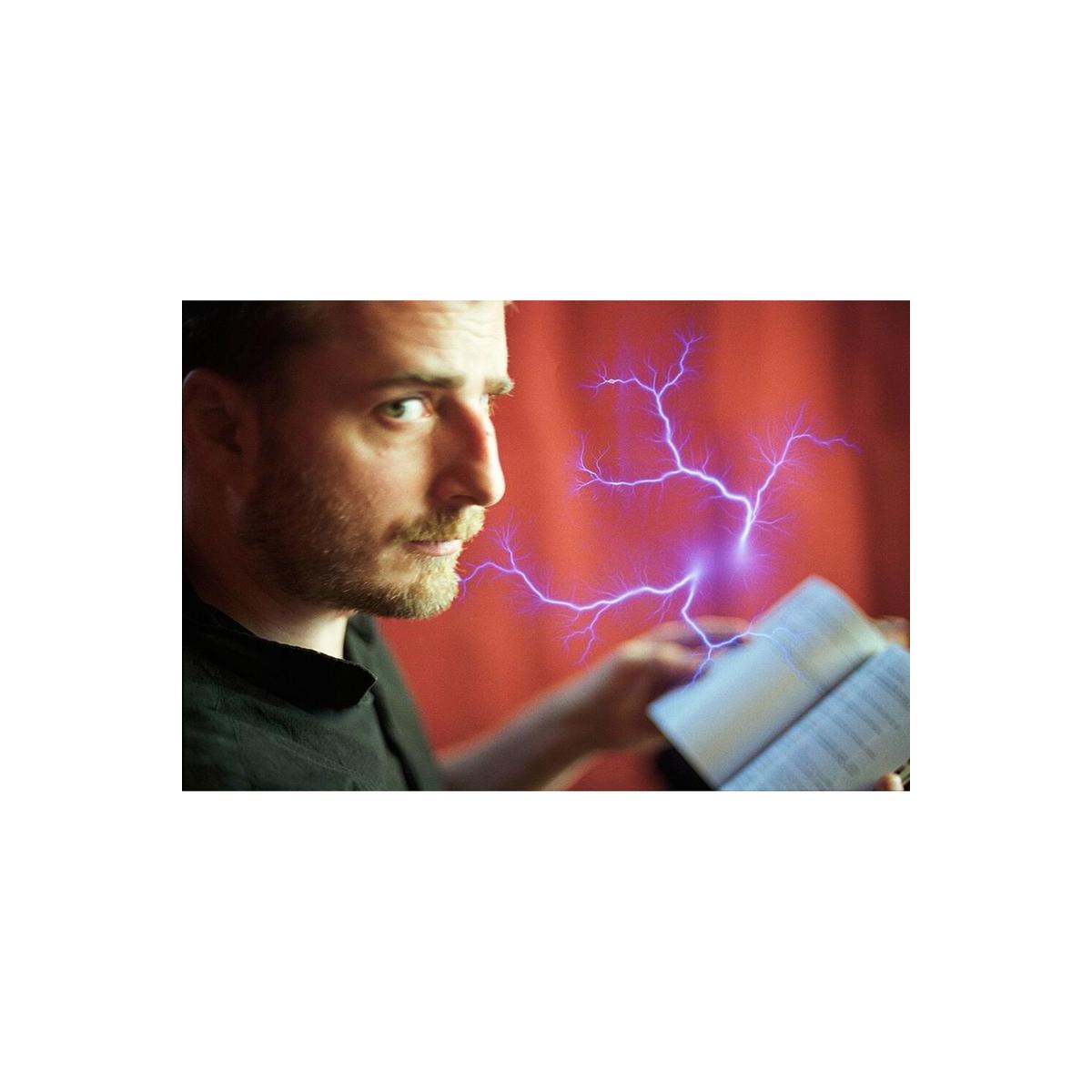 Portrait of a man holding a book with a vibrant blue lightning bolt effect overlaid on 35mm color negative film.