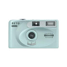 Light blue Reto Project PANO 35mm film camera with a 22mm wide-angle lens, built-in flash, and compact rectangular design.