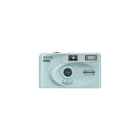 Light blue Reto Project PANO 35mm film camera with a 22mm wide-angle lens, built-in flash, and compact rectangular design.