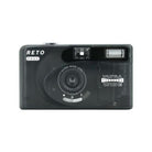 Compact black Reto PANO 35mm film camera with a 22mm ultra-wide lens and built-in flash in a sleek, lightweight design.