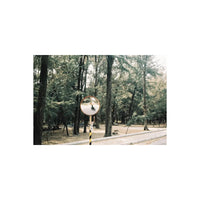 A street view in a forest reflected in a round mirror, captured with RetoColor Glow 400 film’s warm, soft vintage aesthetic.
