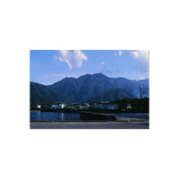 Vibrant landscape shot on RetoColor Mosaic 100 35mm film showing a coastal town, calm blue water, and majestic mountains.