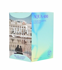 A box of Retocolor Aqua 400 ISO 35mm color negative film with a picture of a serene water body and trees on the packaging.