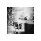 Black and white medium format film shot showing a person reflected in a mirror with vintage wallpaper and high grain.