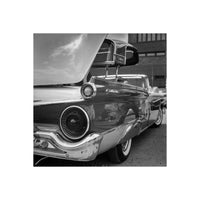 Black and white medium format shot of a vintage Ford Galaxie tail light and chrome bumper with high contrast detail.