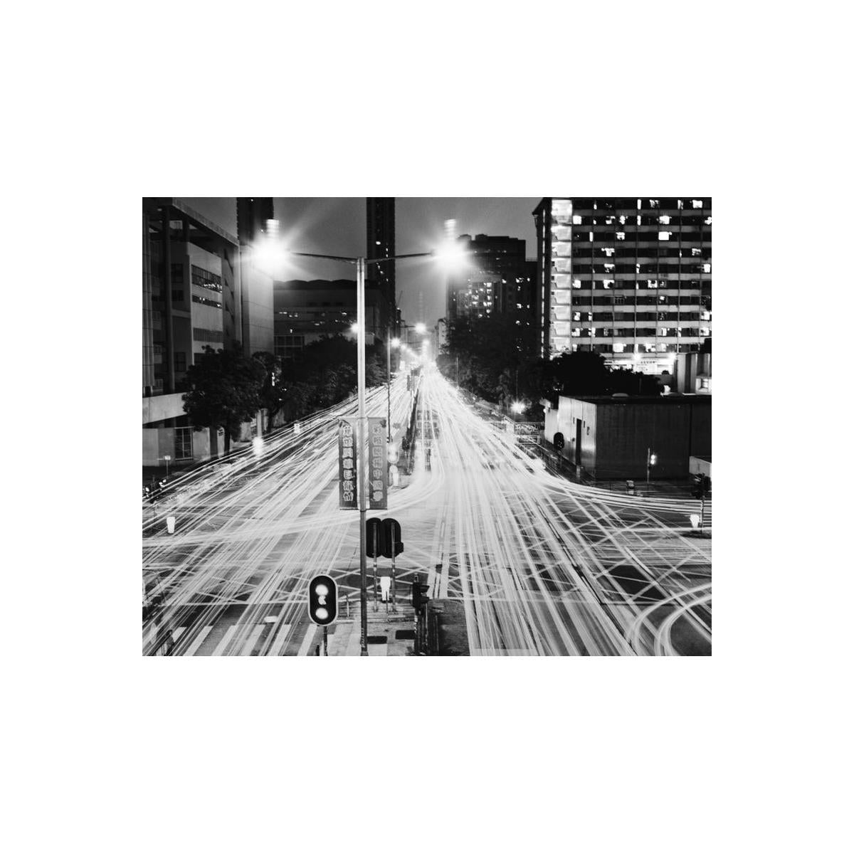 City street at night with light trails from moving vehicles