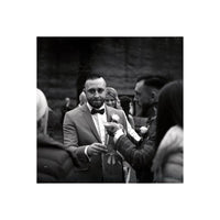 Man in a suit receiving a boutonniere at an event