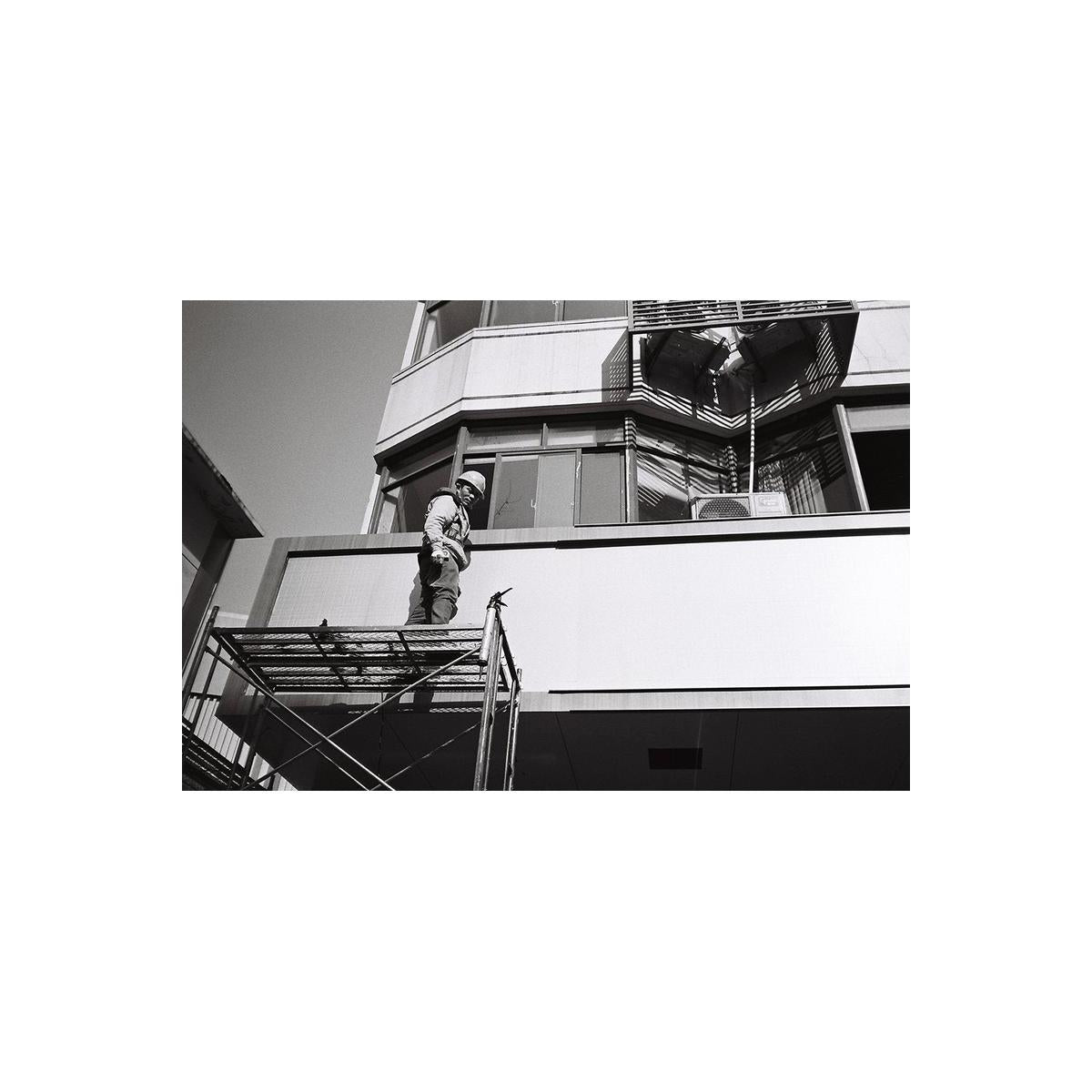 Person on a ladder against a building facade