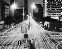 City street at night with light trails from moving vehicles