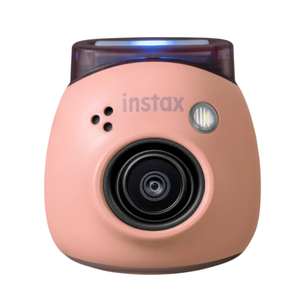 A pink FUJIFILM INSTAX PAL digital camera with a wide-angle lens, display screen, and buttons on the top.