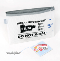 A white zip bag with text and icons indicating it should not be X-rayed, along with a set of film-themed stickers designed by Sissi Lu.