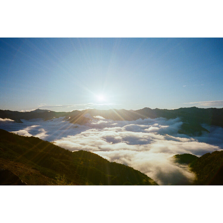 Snapic image of Sunrise over a mountain range with clouds below