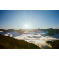 Snapic image of Sunrise over a mountain range with clouds below