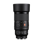 Black Sony FE 100mm f/2.8 G Master macro lens with focus ring, aperture dial, and control switches on white background.