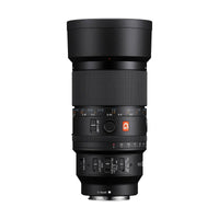 Black Sony FE 100mm f/2.8 G Master macro lens with focus ring, aperture dial, and control switches on white background.