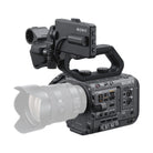 Sony FX6 cinema camera body in matte black with a top handle, side control panel, and attached lens on white background.