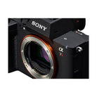 Black Sony a7R VI mirrorless camera body with orange E-mount ring and visible sensor detail.