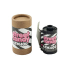 Street Candy ATM 400 35mm black and white film roll next to its branded cardboard storage canister.