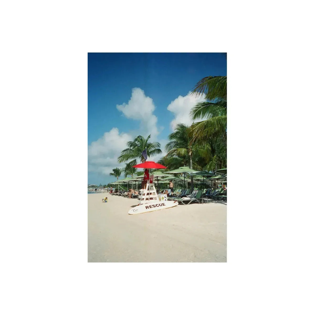 Lifeguard chair with a red umbrella on a sunny beach, captured on Vandal Tungsten 400 color 35mm film with distinct halation.