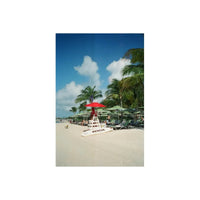 Lifeguard chair with a red umbrella on a sunny beach, captured on Vandal Tungsten 400 color 35mm film with distinct halation.