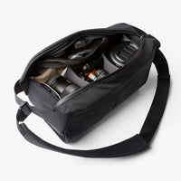 Black camera bag with a camera inside on a white background