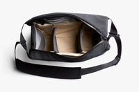 Black duffel bag with beige interior on a white background