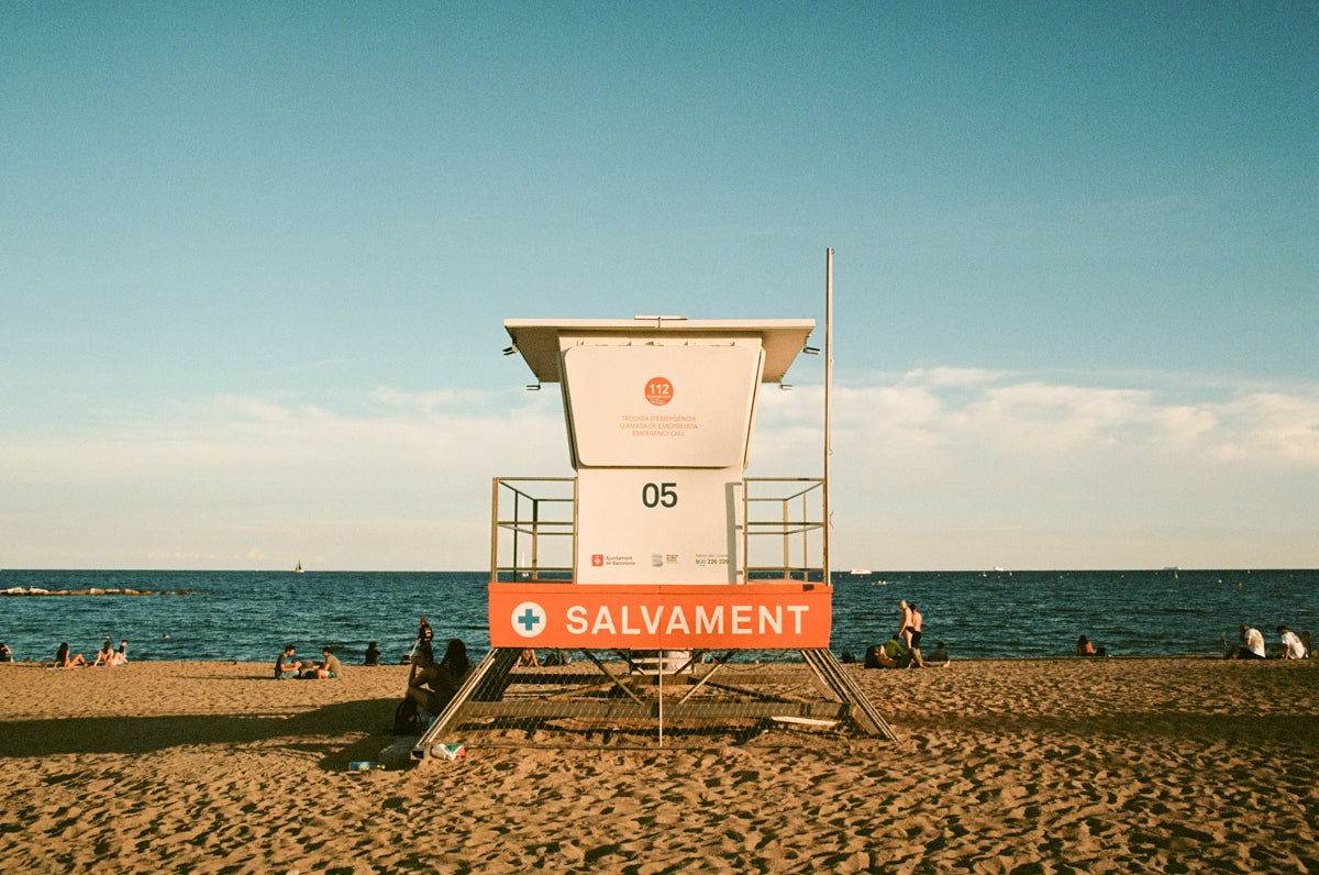 Lifeguard tower on a sandy beach with ocean and clear sky in the background