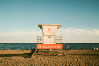 Lifeguard tower on a sandy beach with ocean and clear sky in the background
