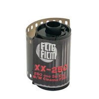 A roll of FLIC Film XX-250 250 ASA 36 Etp B/W Cinema Film, showing the black plastic core, black label, and exposed silver film strip on a light gray background.